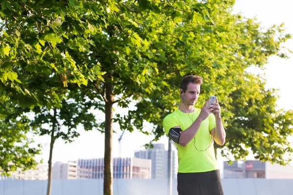 Sportsman använder sin mobiltelefon — Stockfoto