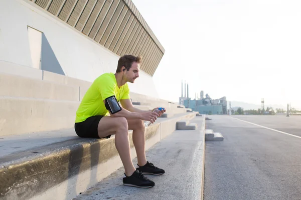 Atleta masculino sentado em escadas pavimentadas — Fotografia de Stock