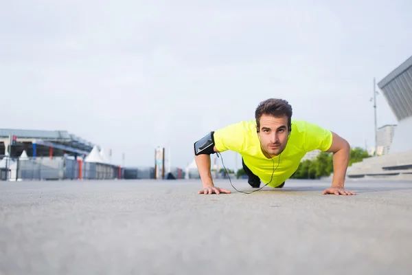 Sporsman  in bright sportswear doing push-ups — Stock Photo, Image