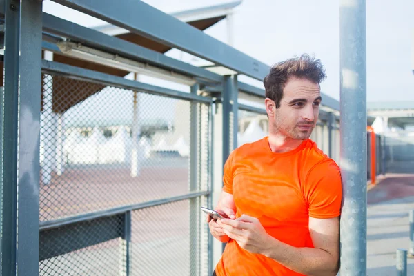 Young sportsman using his smartphone — Stock Photo, Image