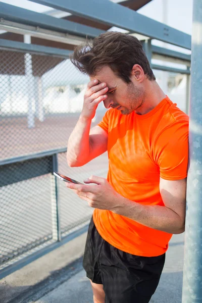 Male athlete using his smartphone — Stock Photo, Image