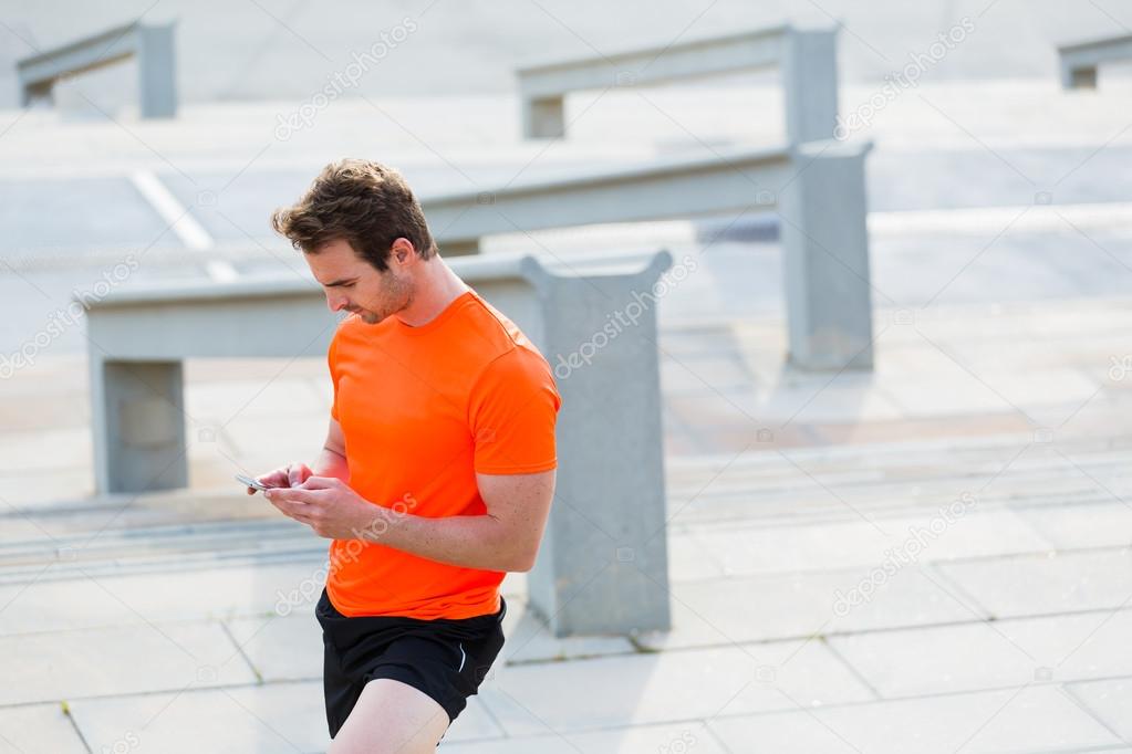 Young male athlete using his smartphone