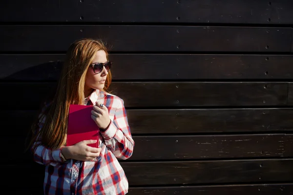 Girl standing against wooden wall — 图库照片