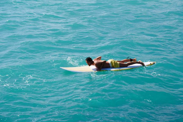 Surfer schwimmt auf seinem Surfbrett in den Wellen — Stockfoto