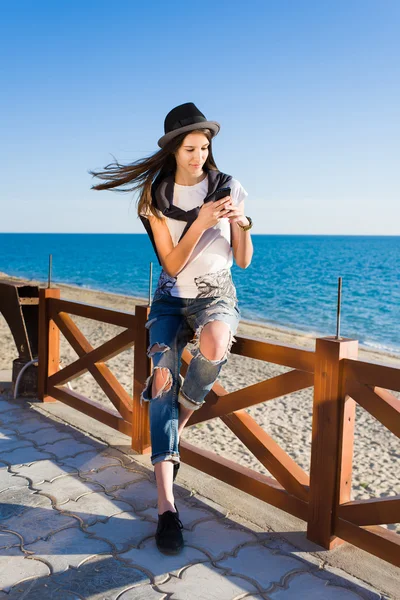 Menina jovem hipster usando telefone móvel — Fotografia de Stock