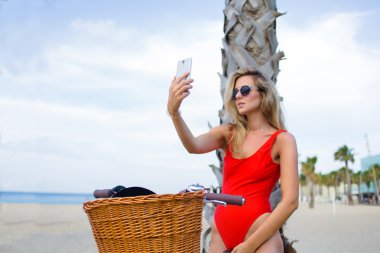 Hipster girl in swimwear taking self portrait