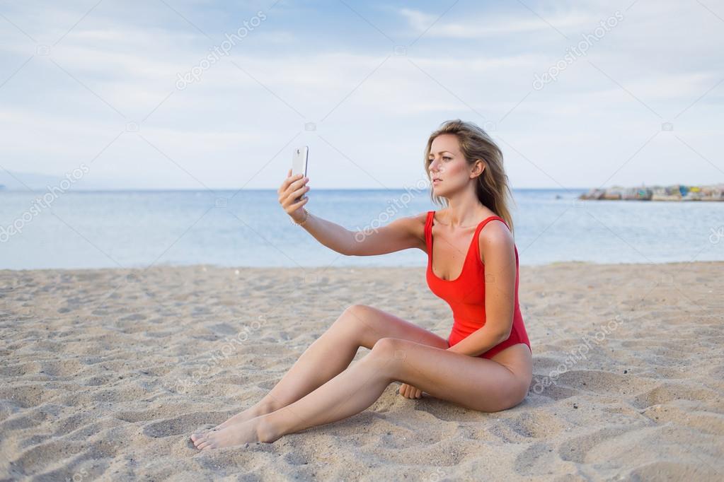 Woman in red swimsuit doing self portrait