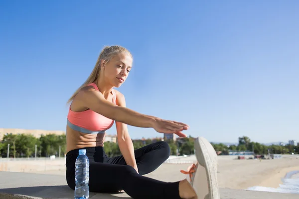 Athletic female stretching legs muscles — Zdjęcie stockowe