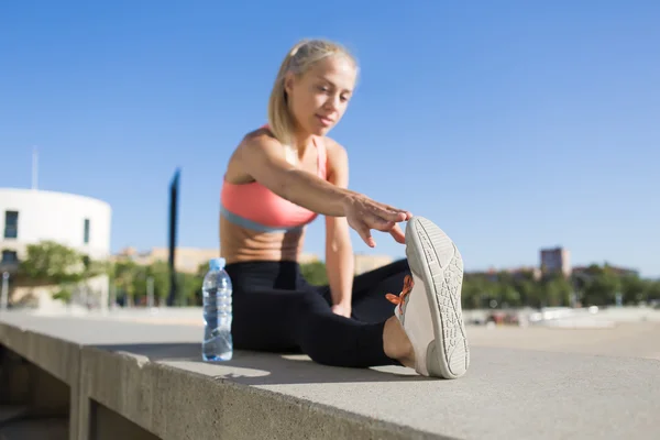 Athletic female stretching legs muscles — Zdjęcie stockowe