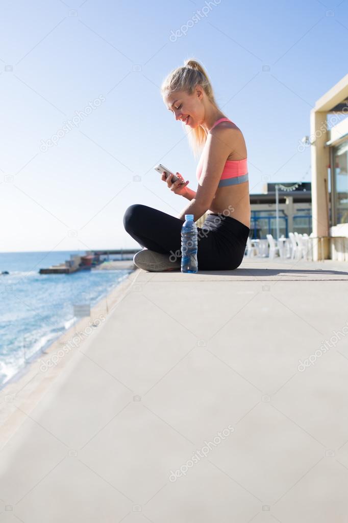 Fitness woman using her mobile phone