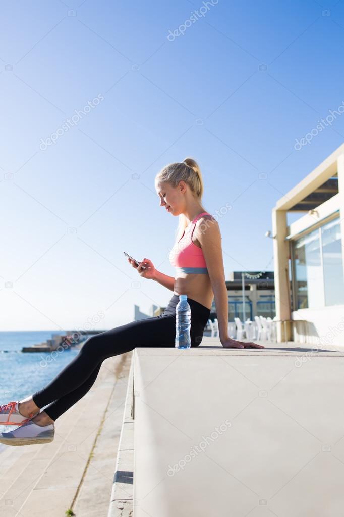 Fitness woman using her mobile phone