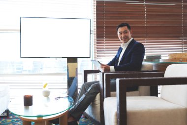 Businessman sitting in office near empty screen