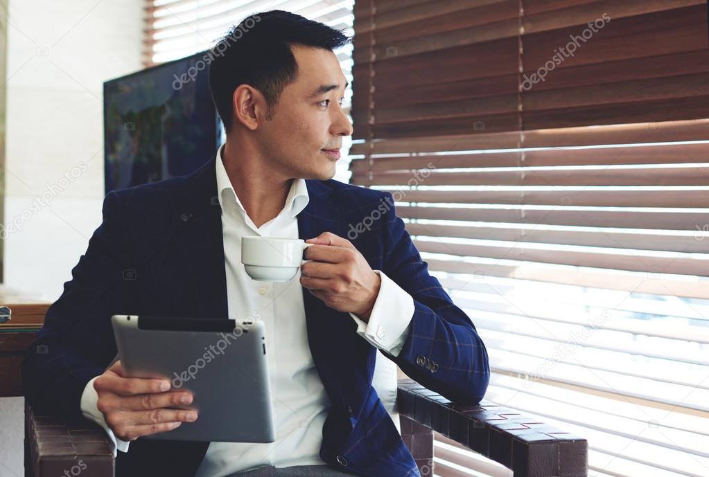 Young confident businessman enjoying coffee