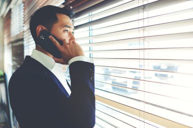 Asyalı işadamı cep telefonuyla konuşuyor