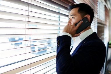 Asyalı işadamı cep telefonuyla konuşuyor