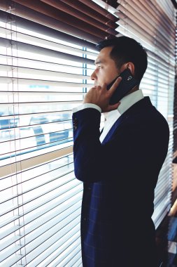 Asyalı işadamı cep telefonuyla konuşuyor