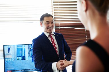 Smiling businessman shaking hands in honor