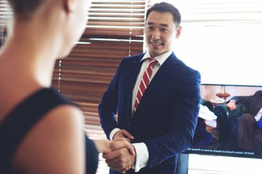 Smiling asian businessman shaking hands