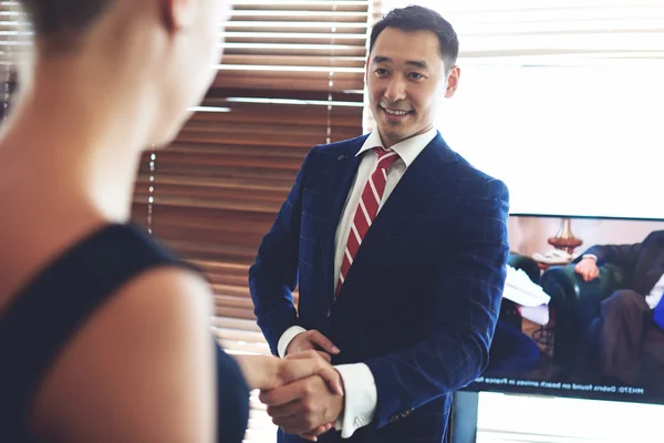 Smiling asian businessman shaking hands — Stock fotografie