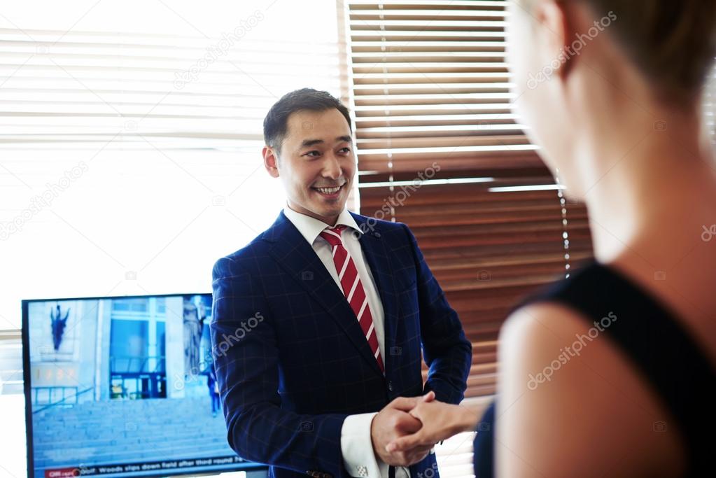 Smiling businessman shaking hands in honor