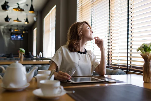 Wanita yang duduk dengan tablet digital dan headphone — Stok Foto