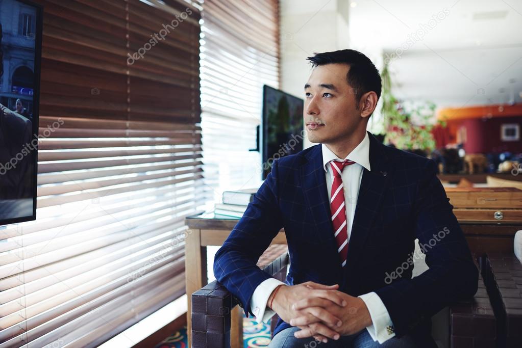 Asian businessman watching television
