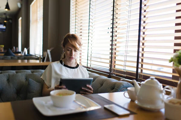 Frau surft auf ihrem Tablet im Internet — Stockfoto