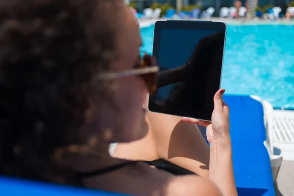 Woman in bikini holding touch pad — Stockfoto