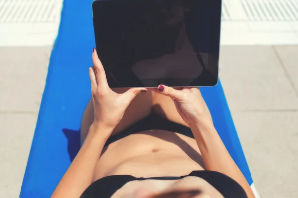 Female in bikini with touch pad near pool — Stockfoto