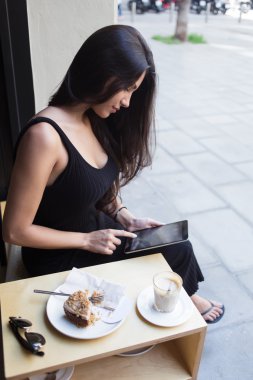 Woman using her digital tablet in cafe