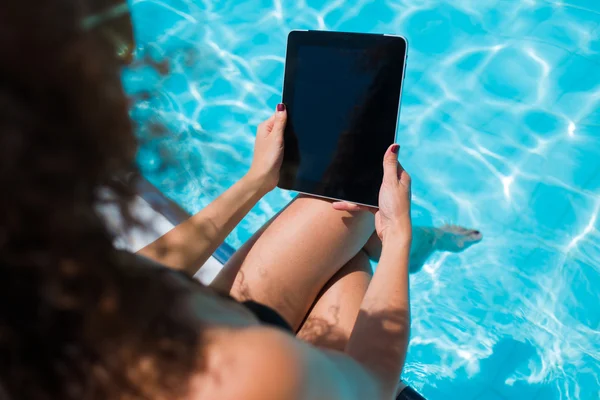 Mujer en bikini con almohadilla táctil cerca de la piscina — Foto de Stock