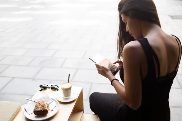 Wanita menggunakan tablet digitalnya di kafe — Stok Foto
