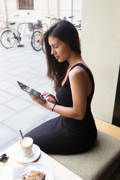 Woman using her digital tablet in cafe — Zdjęcie stockowe