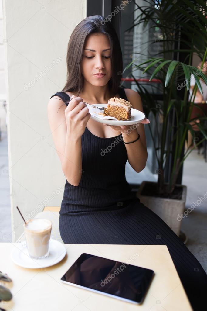 Woman eating dessert in cozy cafe