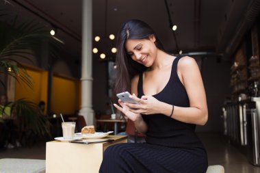 Woman using her mobile phone in cafe