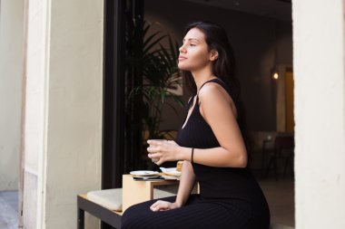 Woman enjoying work break in cafe