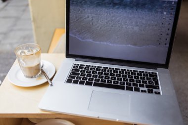 Open laptop computer on table in cafe