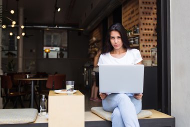 Young hipster girl working on her net-book