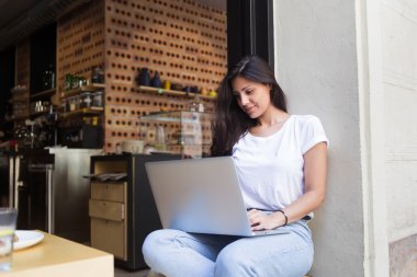 Young hipster girl working on her net-book