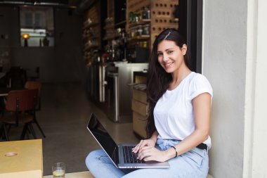 Young hipster girl working on her net-book