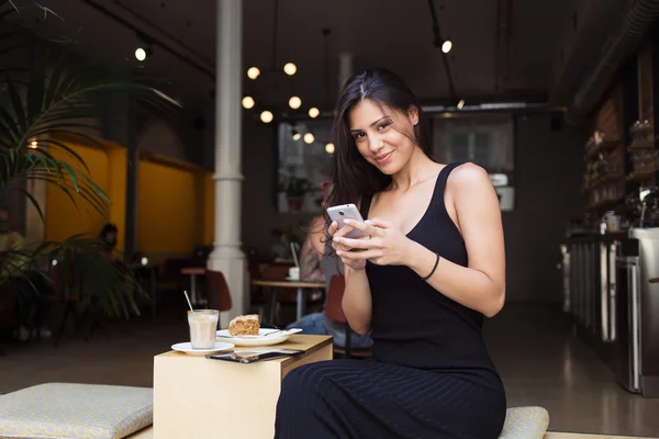 Frau benutzt ihr Handy im Café — Stockfoto
