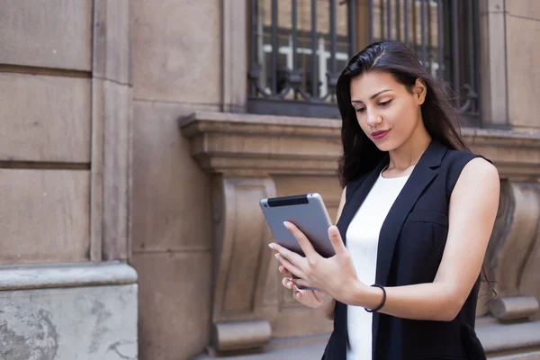 Woman with digital tablet in urban setting — ストック写真