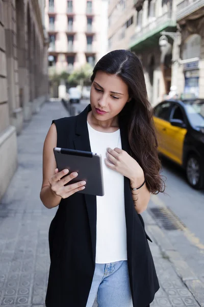 Woman with digital tablet in urban setting — ストック写真