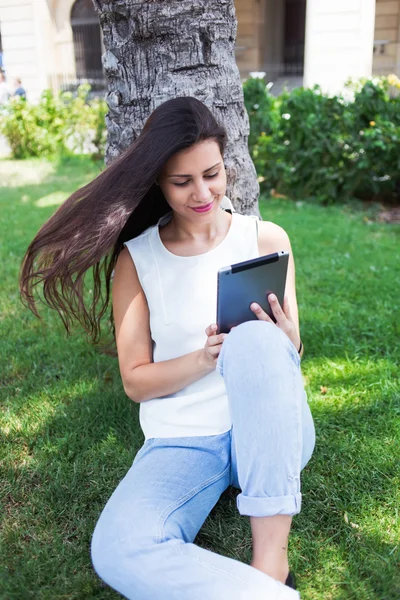 Женщина использует планшетный компьютер на открытом воздухе — стоковое фото