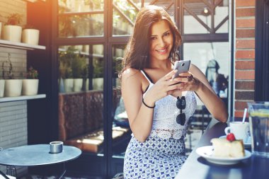 Smiling woman using the mobile phone
