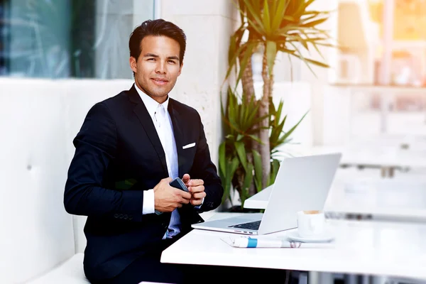 Businessman sitting front of netbook at restaurant — Stock Photo, Image