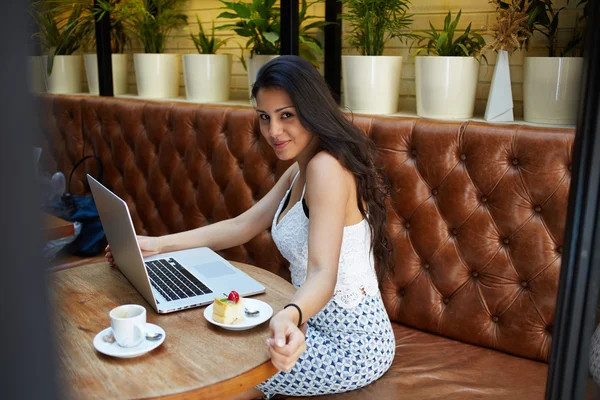 Woman working on her laptop in cafe — ストック写真