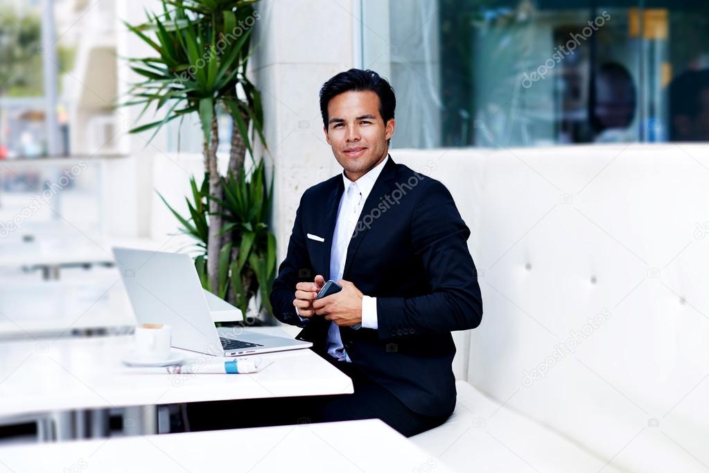 Successful businessman sitting in front of netbook