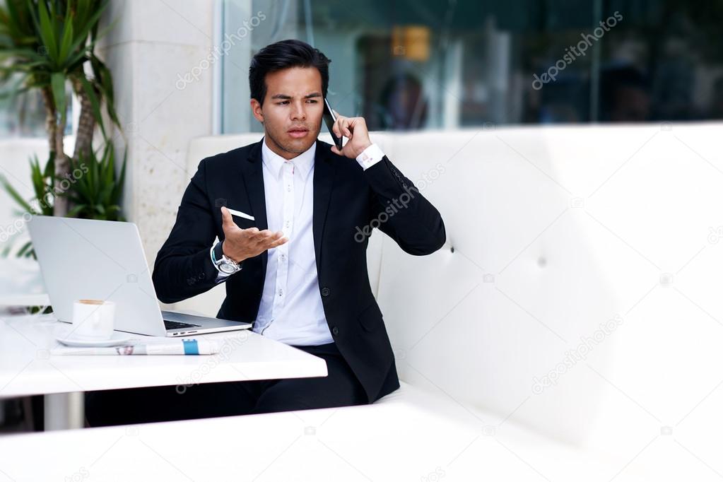 Worried businessman talking on mobile phone
