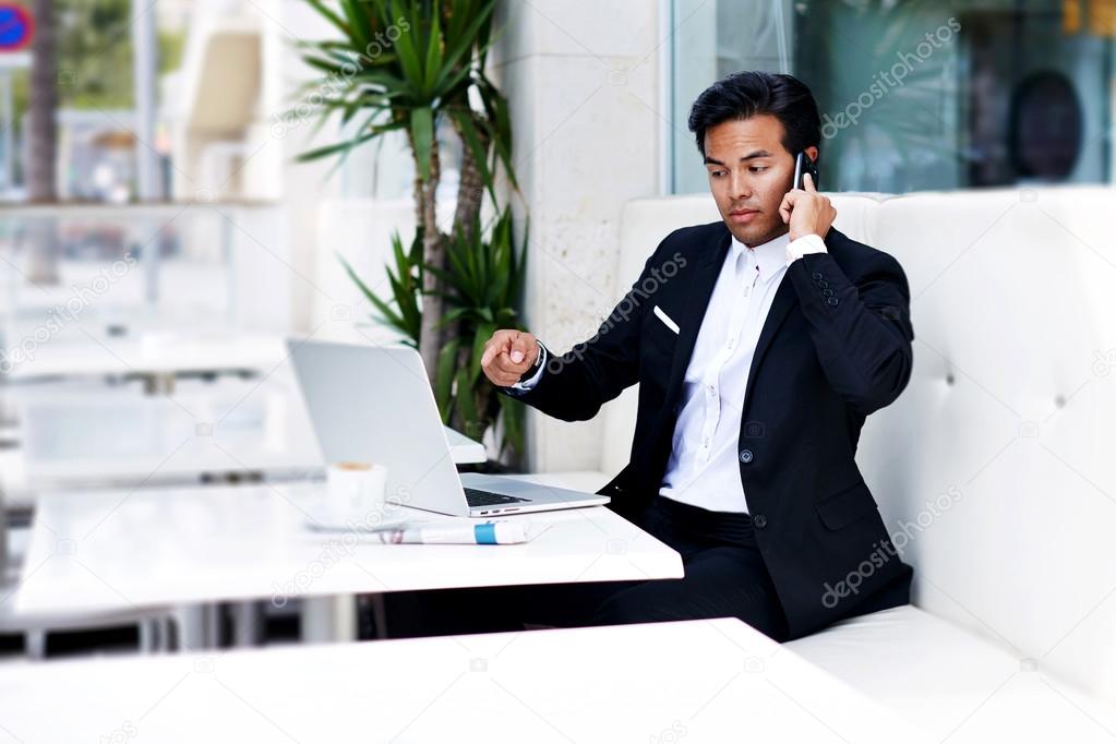 Angry businessman talking on mobile phone